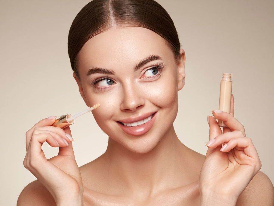 Frau trägt Concealer auf