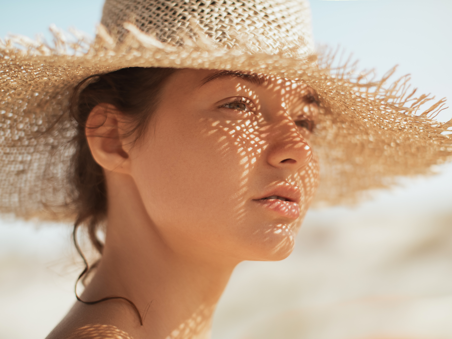 Frau mit Sonnencreme unter Make-up