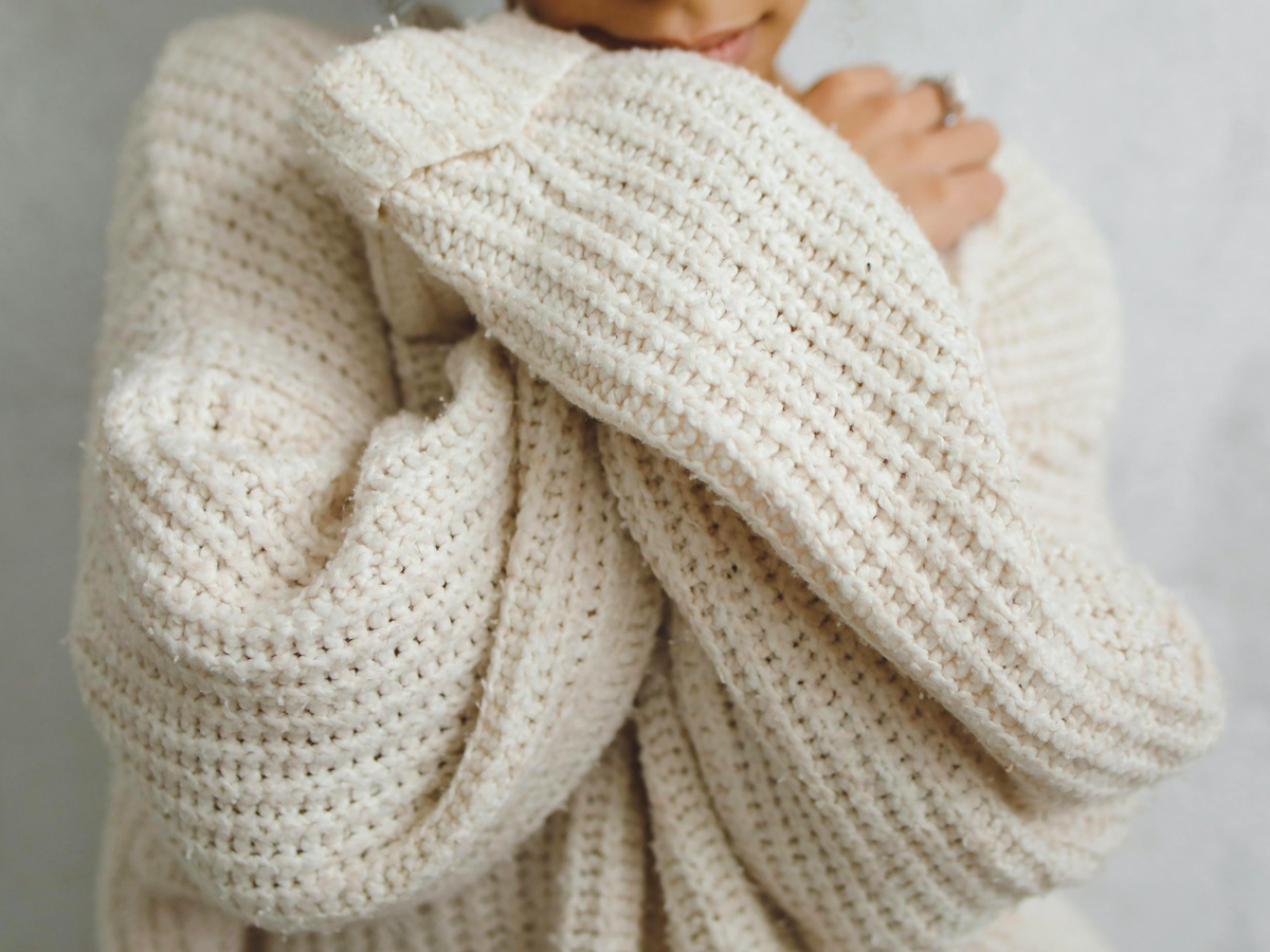Eine Frau trägt einen selbst gestrickten Pullover aus warmer Wolle