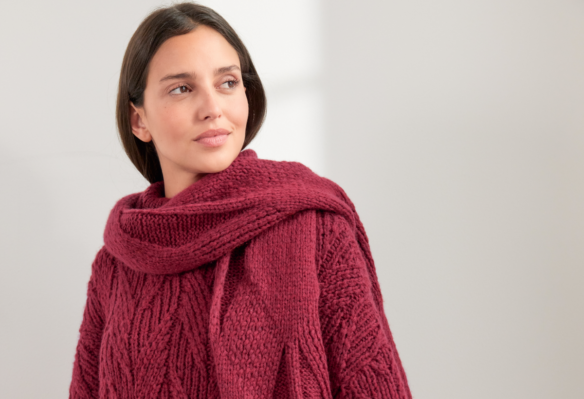 Model in Rautenschal und Pullover in Beerentönen von Lana Grossa