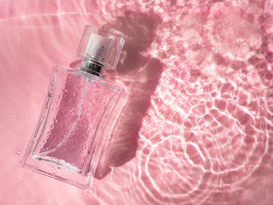 Ein Parfumflakon in seichtem Wasser liegend