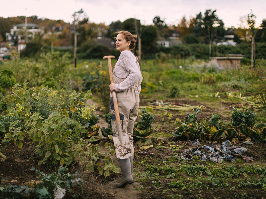 Eine Frau im Overall, die im Garten arbeitet