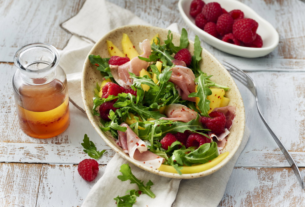 Rucolasalat mit Mango, Himbeeren und Schinken
