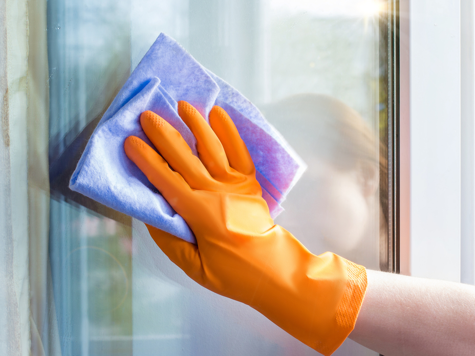 Frau putzt Fenster