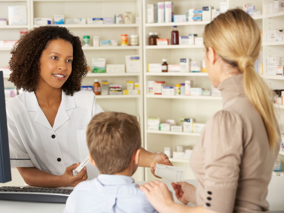 Apothekerin berät Frau mit Kind
