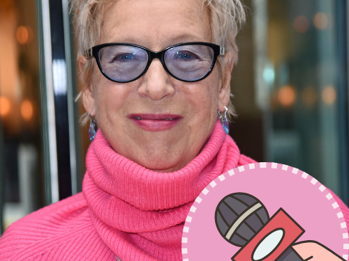 Regisseurin, Produzentin, Autorin Doris Dörrie lächelt aufgeweckt in die Kamera. Sie trägt einen knallig pinken Pullover und eine Brille mit blau getönten Gläsern.