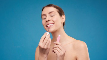Frau trägt ein Lippenprodukt auf