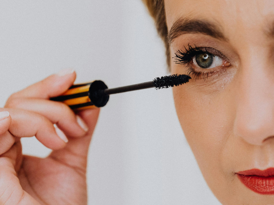 Frau trägt wasserfeste Mascara auf ihre Wimpern auf