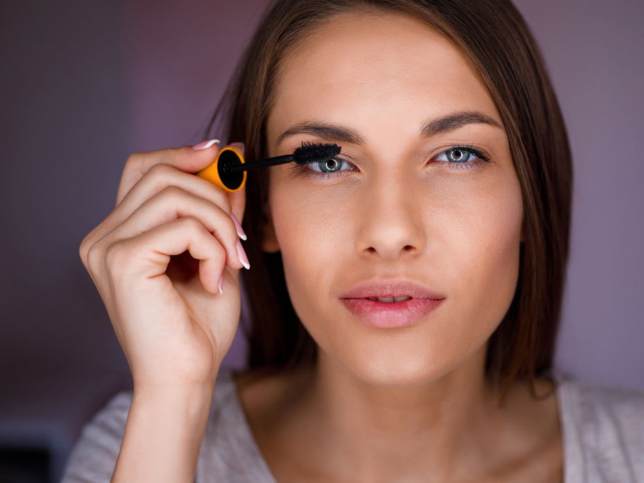 Frau im Close-up tuscht wimpern