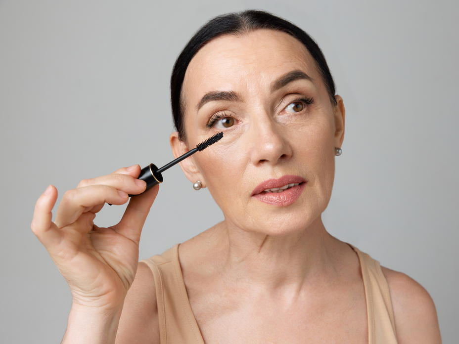Frau trägt mit dem Mascara-Trick für Schlupflider Wimperntusche auf