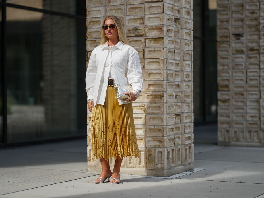 Eine Besucherin der Kopenhagen Fashion Week kombiniert silberne Sandalen zum Faltenrock