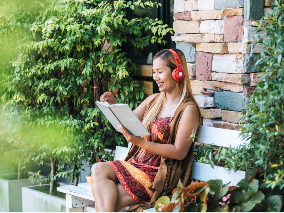 Eine Frau liest ein Buch im Garten