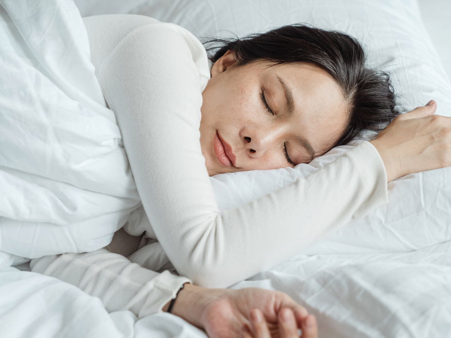 Eine Frau schläft in ihrem Bett