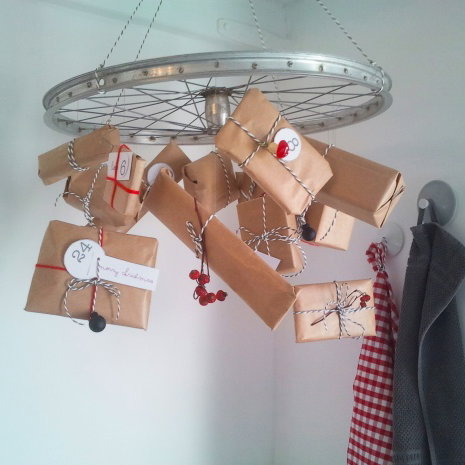 Selbstgemachter Adventskalender mit Geschenken an einem Rad