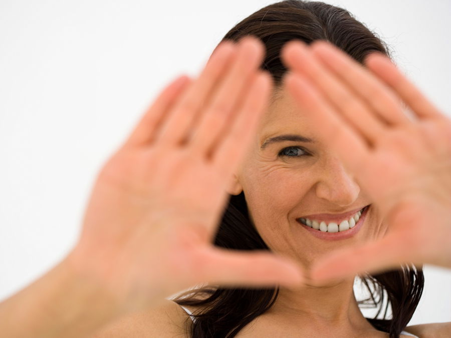 Frau versteck ihr Gesicht - Mit unseren Tipps können Sie die Fältchen zumindest ein wenig eindämmen