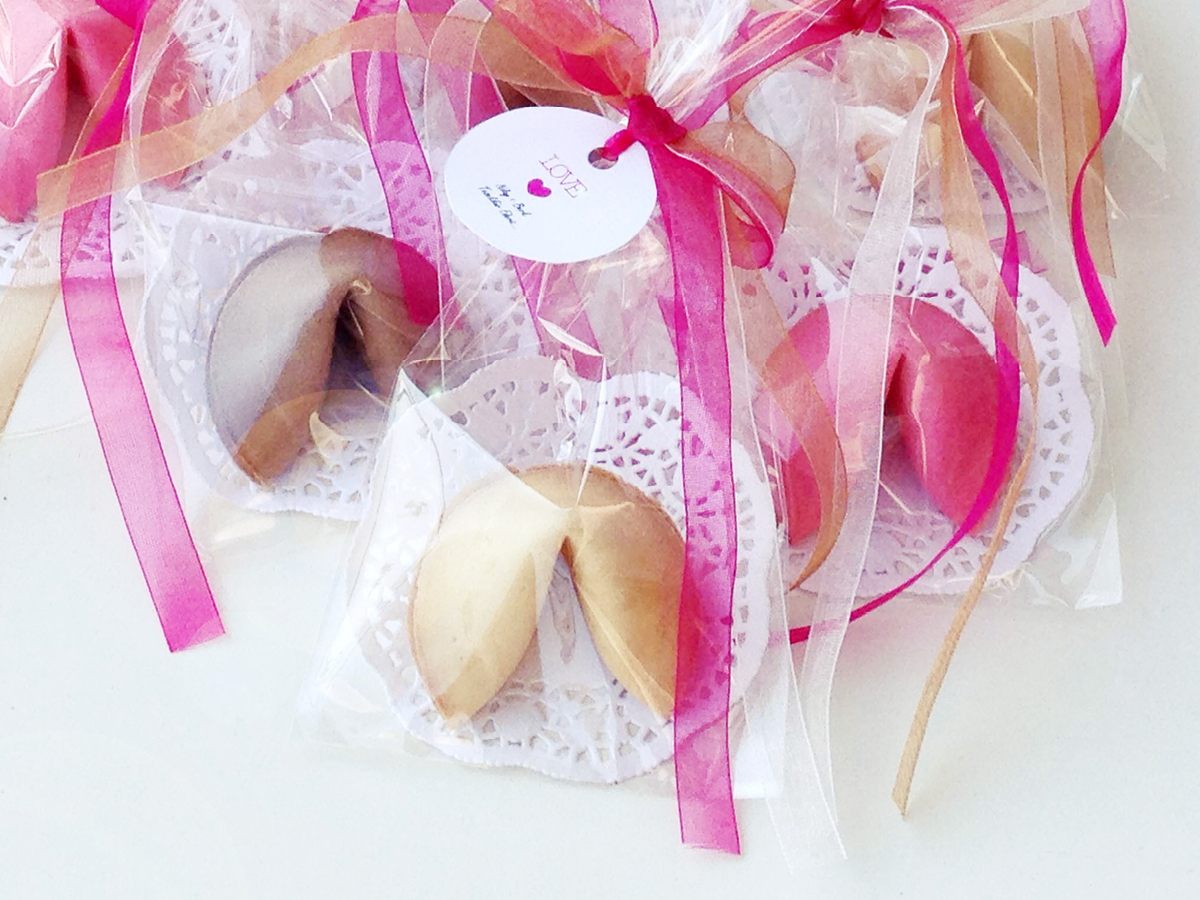 Glückskekse mit rosa Geschenkband als Geschenk zur Hochzeit