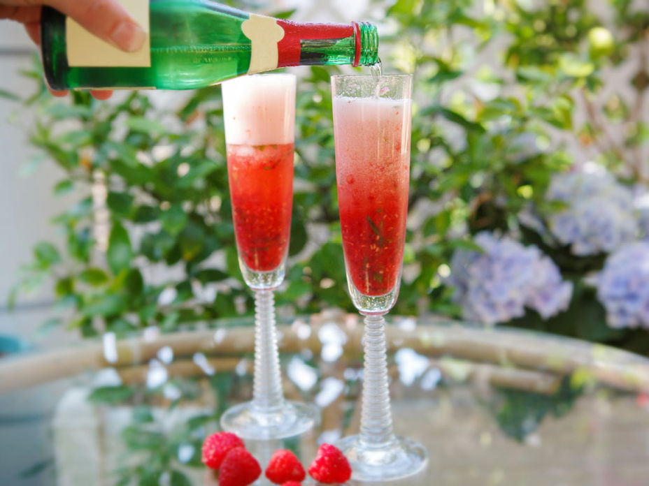 Sekt wird auf Erdbeeren eingeschenkt