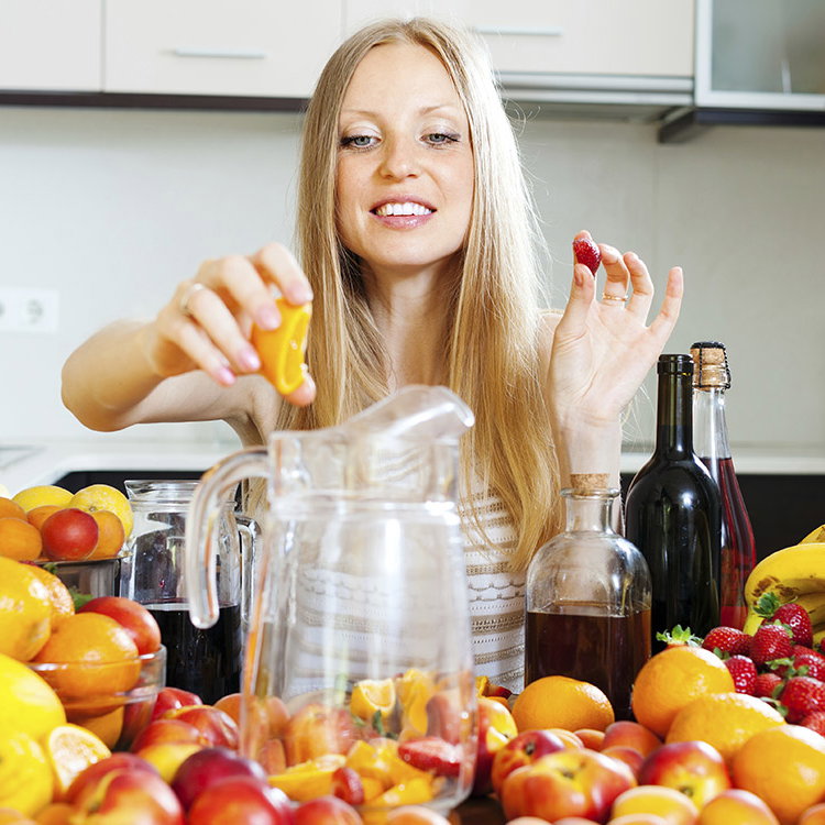 Eine Frau probiert, welches Früchte Sie zum Saft-Fasten verwenden möchte