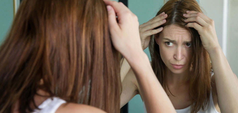 Frau prüft graue Haare – graue Haare durch Stress
