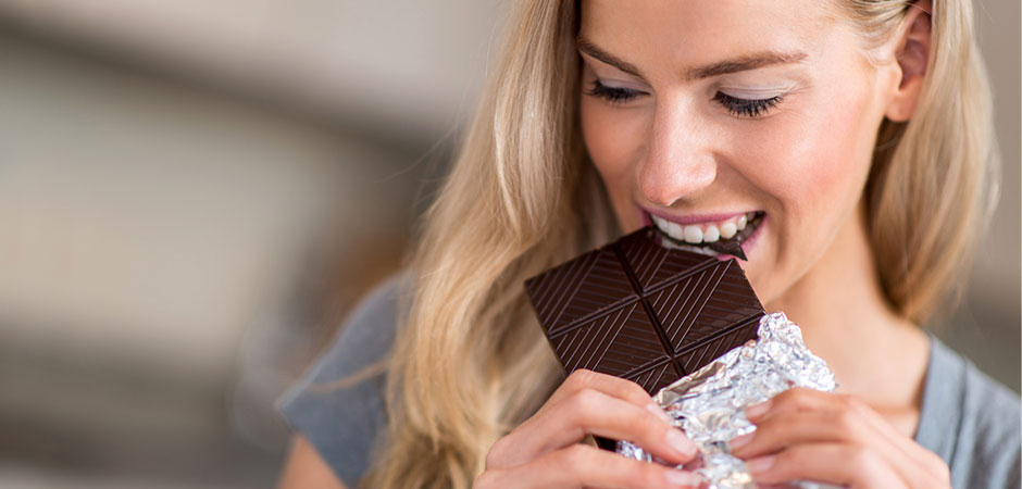 Frau isst Schokolade - ist Zucker ungesund für die Haut?