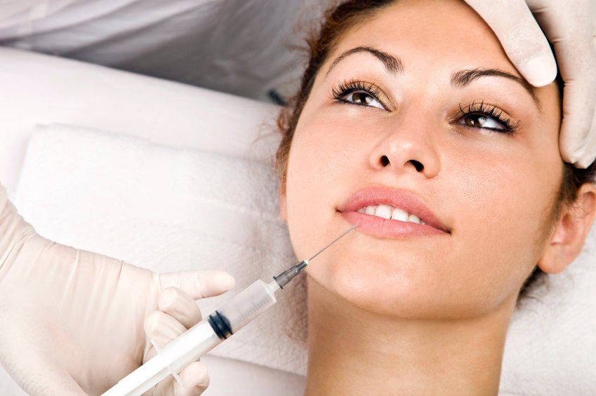 Frau bekommt auf einem Arztstuhl Botox gespritzt
