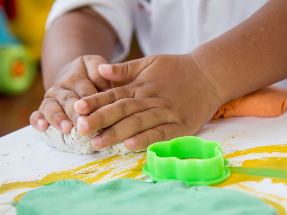 Kinderhände beim Selbermachen von Knete
