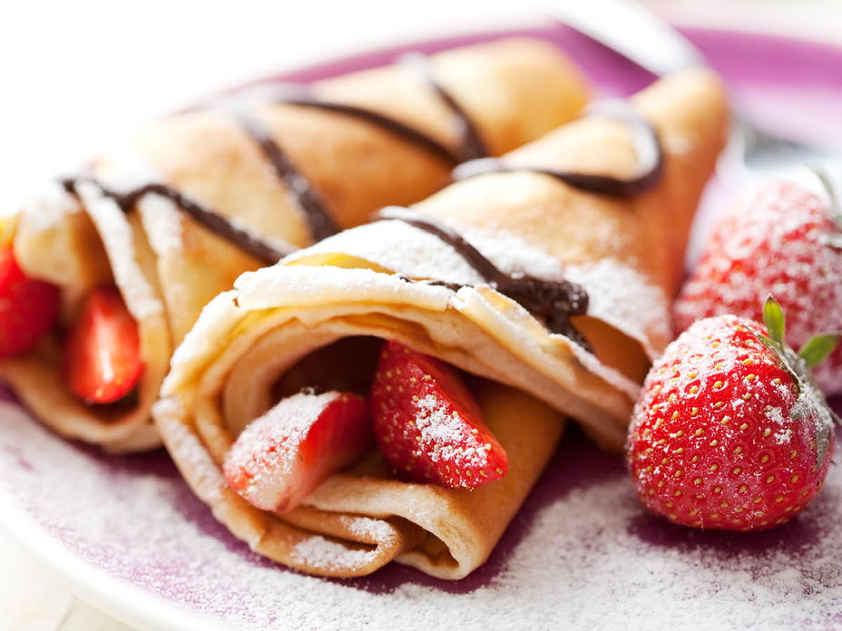 Eierkuchen mit Schokolade, Puderzucker und Erdbeeren