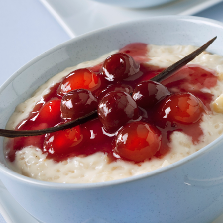 Schale mit Milchreis und Kirschen
