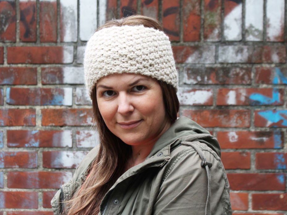 Strickbloggerin Jessica trägt ein selbstgestricktes Stirnband.