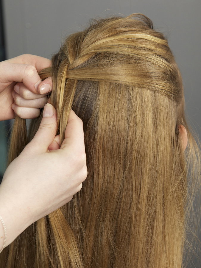 Haare einer Frau werden am Hinterkopf geflochten