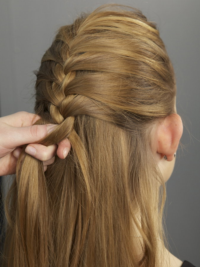 Frau flechtet die Haare einer anderen Frau