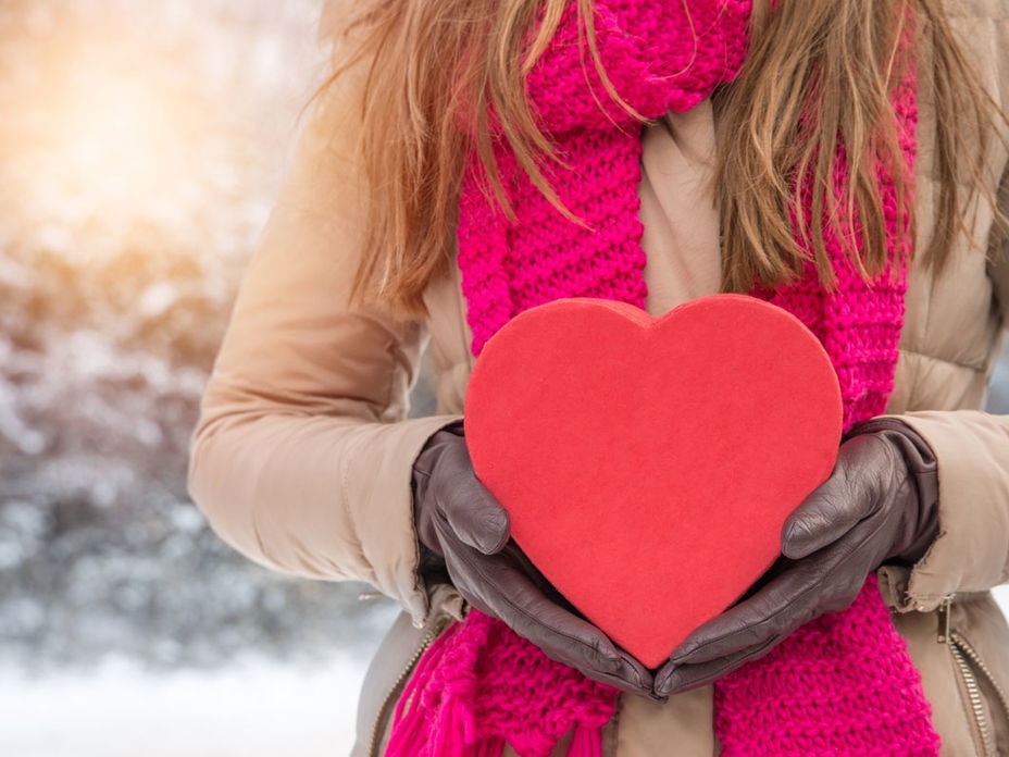 Frau hält Geschenk für Mann zum Valentinstag - Tipps für das richtige Valentinstagsgeschenk für Männer
