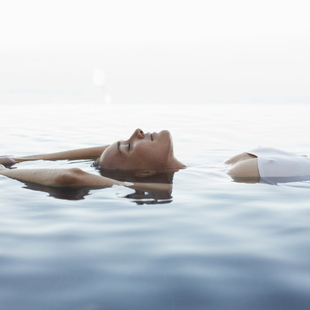 Frau liegt im Meer